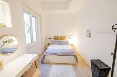 two beds in a white room with a mirror at Vintage and Design in the Heart of Vibrant Pigneto in Rome