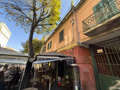 a street with a shop with a tree and a building at Vintage and Design in the Heart of Vibrant Pigneto in Rome