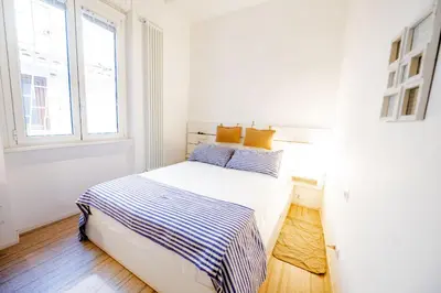 a white bedroom with a bed and a window at Vintage and Design in the Heart of Vibrant Pigneto in Rome
