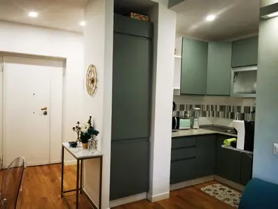 a kitchen with green cabinets and a table at La verde dimora in Rome