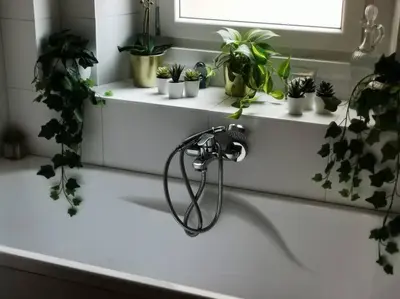 a bathroom sink with a hose on it with potted plants at La verde dimora in Rome