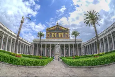 a large building with a statue and palm trees at La verde dimora in Rome