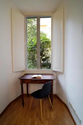 a desk with a chair in front of a window at La Casa Romana in Rome