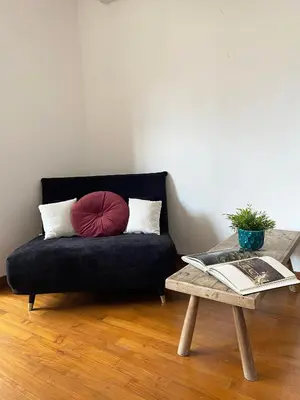 a black couch with a red pillow and a table at Bright Penthouse 2 M stops from Vatican Museums in Rome