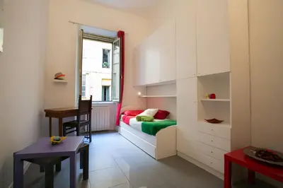 a room with a bed and a desk and a table at Alloggio Turistico Cadorna - Fontana di Trevi , Via Veneto Piazza di Spagna in Rome