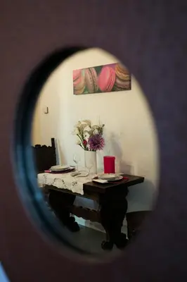 a table with plates and a vase of flowers at Alloggio Turistico Cadorna - Fontana di Trevi , Via Veneto Piazza di Spagna in Rome