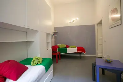 a bedroom with two beds with red and green sheets at Alloggio Turistico Cadorna - Fontana di Trevi , Via Veneto Piazza di Spagna in Rome