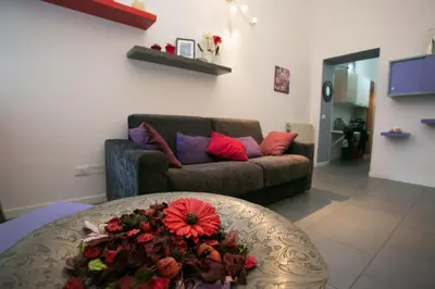 a living room with a couch and a table with flowers at Alloggio Turistico Cadorna - Fontana di Trevi , Via Veneto Piazza di Spagna in Rome