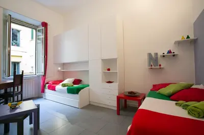 a bedroom with two beds and a table and a desk at Alloggio Turistico Cadorna - Fontana di Trevi , Via Veneto Piazza di Spagna in Rome