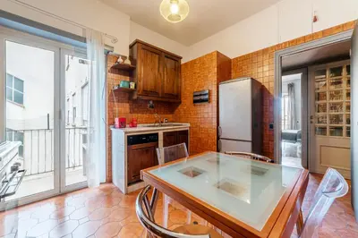 a kitchen with a table and a refrigerator at GuestHost - MM Re di Roma Apartment in Rome