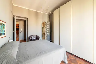 a bedroom with a large bed and a chair at GuestHost - MM Re di Roma Apartment in Rome