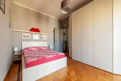 a bedroom with a large bed and white cabinets at GuestHost - MM Re di Roma Apartment in Rome