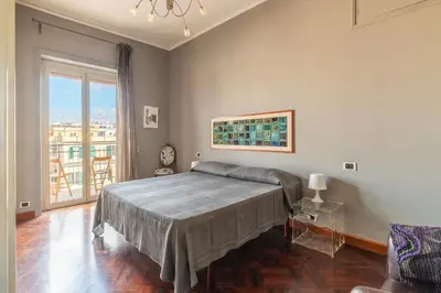 a bedroom with a bed and a large window at GuestHost - MM Re di Roma Apartment in Rome