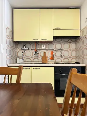 a kitchen with white cabinets and a wooden table at Dolce Casa in San Pietro in Rome