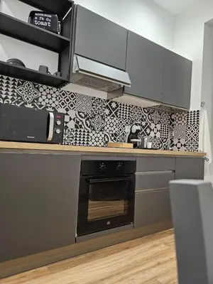 a kitchen with a black and white tiled wall at Apartment Roma Centro San Pietro e Musei Vaticani in Rome
