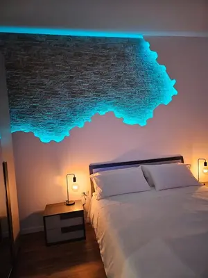 a bedroom with a bed and a wall with blue lights at Apartment Roma Centro San Pietro e Musei Vaticani in Rome