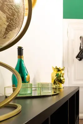 a table with a green bottle and a mirror at TP Apartment Luxury Colosseum in Rome