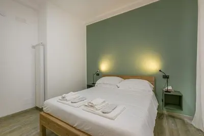 a bedroom with a large white bed with two towels on it at Borgo Vittorio 20 Vatican Home in Rome