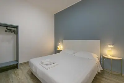 a bedroom with a large white bed with two lamps at Borgo Vittorio 20 Vatican Home in Rome