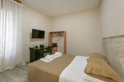 a bedroom with a large bed and a television at Borgo Vittorio 20 Vatican Home in Rome