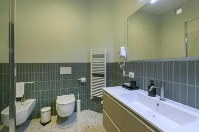a bathroom with a sink and a toilet and a mirror at Borgo Vittorio 20 Vatican Home in Rome
