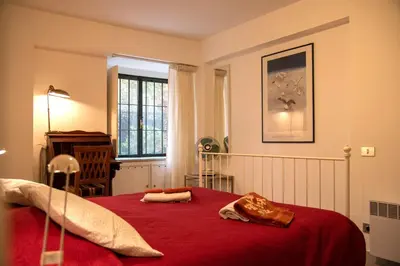 a bedroom with a red bed with a red blanket at Aventino apartment in Rome