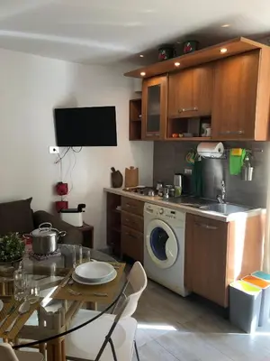 a kitchen with a washing machine and a table at Aventino apartment in Rome