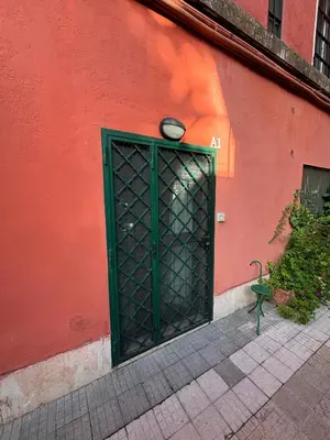 a green door on the side of a red building at Aventino apartment in Rome