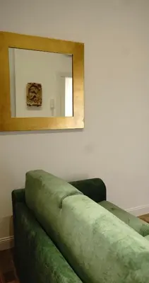 a green couch in a room with a mirror at Piccolo Principe Suite in Rome