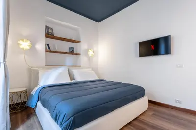 a bedroom with a bed and a tv on the wall at Suite Vaticano in Rome