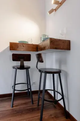 two bar stools and a shelf on a wall at Suite Vaticano in Rome
