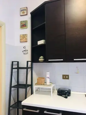 a kitchen with a white counter and a black cabinet at Appartamento di Sara in Rome
