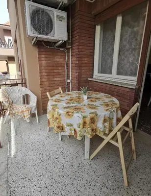 a table and chairs on a patio with a fan at Appartamento di Sara in Rome