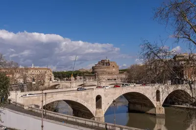 a bridge over a river with cars on it at Castel Sant'Angelo SuiteLux in Rome