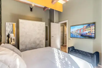 a bedroom with a bed and a tv on the wall at Castel Sant'Angelo SuiteLux in Rome