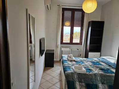 a bedroom with a bed and a television and a window at ST. PETER'S ROOMS SUITE in Rome