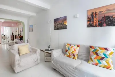 a white living room with a couch and a chair at Minerva al 5 in Rome