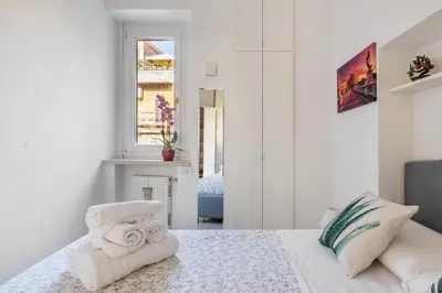 a white bedroom with a bed with towels on it at Minerva al 5 in Rome