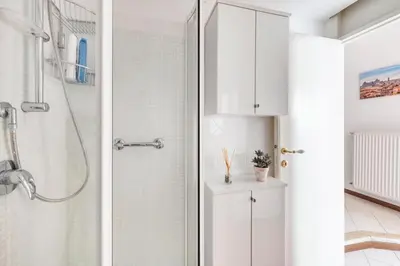 a white bathroom with a shower and a glass door at Minerva al 5 in Rome
