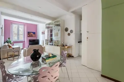 a living room with a glass table and pink walls at Minerva al 5 in Rome