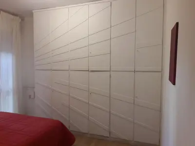 a bedroom with white walls and a red bed at Rizzola casa e appartamento per vacanze in Rome