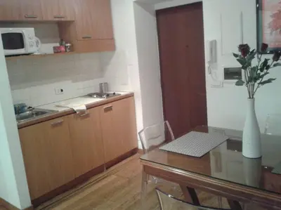 a kitchen with a table and a vase of flowers at Barberini 360 in Rome