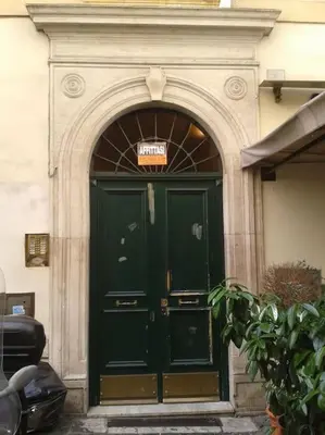 a green door of a building with a sign above it at Barberini 360 in Rome
