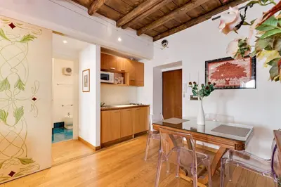 a kitchen and dining room with a table and chairs at Barberini 360 in Rome