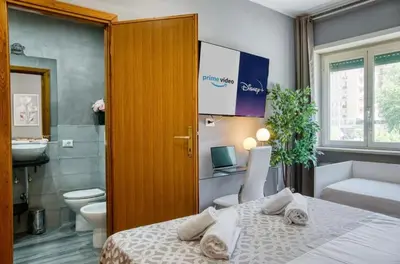 a bedroom with a white bed and a flat screen tv at DomusFebo-VaticanSuites in Rome
