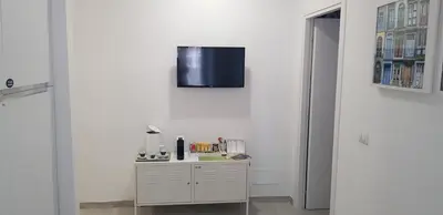 a room with a table and a tv on a wall at Trastevere Residenze in Rome