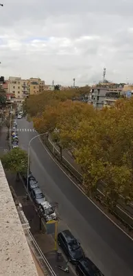 a city street with cars parked on the side of the road at Trastevere Residenze in Rome