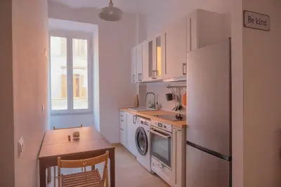 a kitchen with a refrigerator and a sink and a table at Stazione Termini-San Lorenzo Apt House of Wonders in Rome