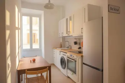 a kitchen with a white refrigerator and a table and a sink at Stazione Termini-San Lorenzo Apt House of Wonders in Rome