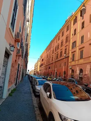 a row of parked cars on a street with buildings at Stazione Termini-San Lorenzo Apt House of Wonders in Rome
